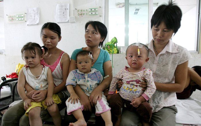 PEKING - Moeders wachten met hun kinderen op behandeling in het ziekenhuis. Foto EPA