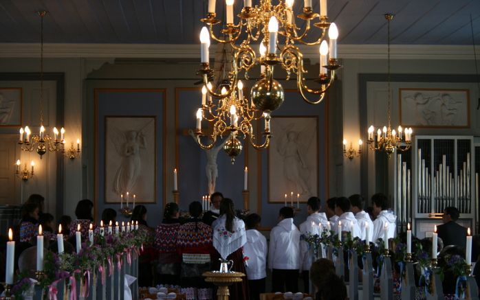 NUUK – De confirmanten in traditionele kledij vormen een halve cirkel rond de evangelisch lutherse priester. Foto Hester Bos