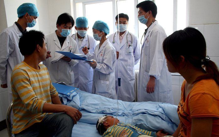 CHINA - Ouders aan het bed van hun tweejarig dochtertje dat besmet is met het enterovirus. Foto EPA