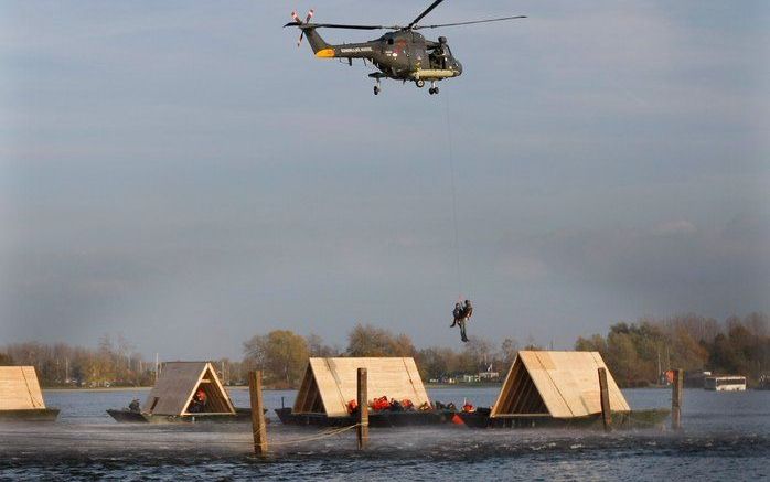 NIJKERK – Een helikopter takelt een hulpverlener met een slachtoffer naar boven vanaf een woningdak na een overstroming. De oefening, op het Nijkerkernauw, vormde de afsluiting van de landelijke oefenweek Waterproef. Het verbeteren van de samenwerking tus