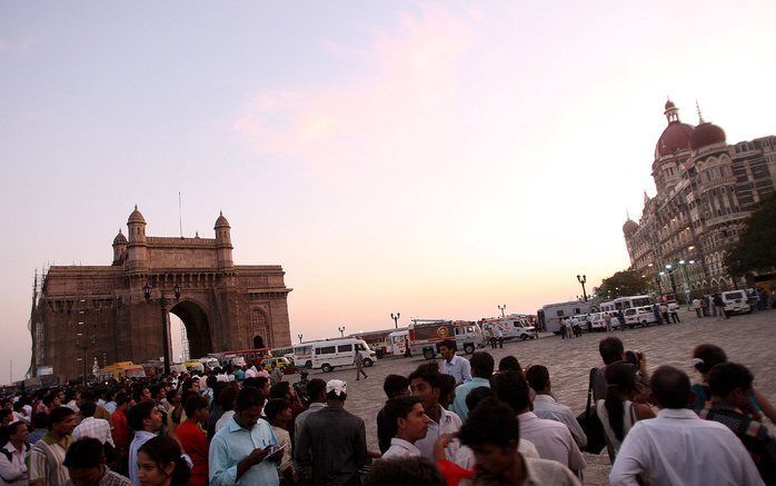 BOMBAY - Gasten en voorbijgangers verzamelen zich buiten het Taj Mahalhotel in Bombay na een schotenwisseling tussen politie en terroristen in het hotel. Foto EPA