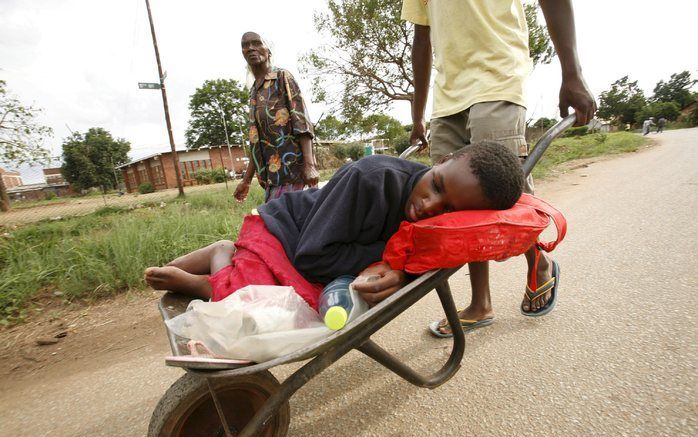 HARARE - Een jonge cholerapatiënt wordt naar een ziekenhuis in de buurt van Harare gebracht. Foto EPA