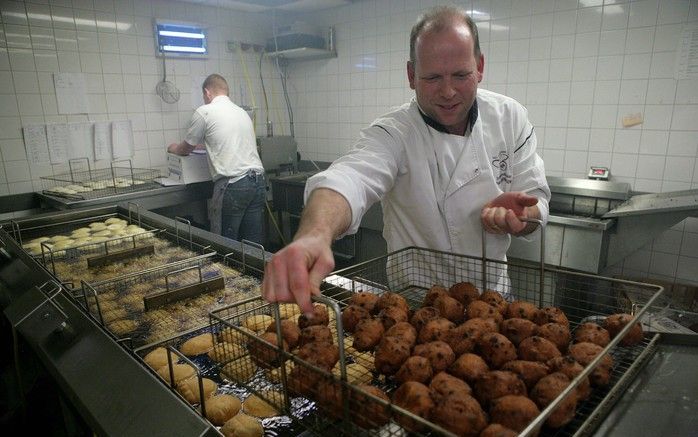 DIDAM - Kampioensbakker Paul Berntsen bezig met het bakken en inpakken van oliebollen. Foto Vidiphoto