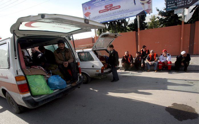 GAZA-STAD - Palestijnen wachten, in Gaza-stad, onderweg naar Egypte. De VN-Veiligheidsraad nam donderdagavond een resolutie aan waarin de VN partijen oproept tot een onmiddellijk en duurzaam staakt-het-vuren. Foto EPA