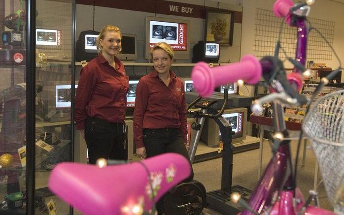 ENSCHEDE – Aimee Rensen (r.) en haar collega in de vestiging van Cash Converters in Enschede. De financiële crisis zorgt voor extra toeloop van mensen die luxe goederen willen verkopen, verpanden of aankopen. Rensen: „Aan verpanden zit geen luchtje meer: 