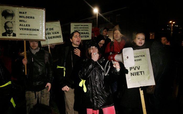 Demonstranten staan maandagavond in Waddinxveen in en rond een speciaal afgezet vak nabij een bijeenkomst waar PVV-leider Wilders praat met aanhangers en andere geïnteresseerden. Foto ANP