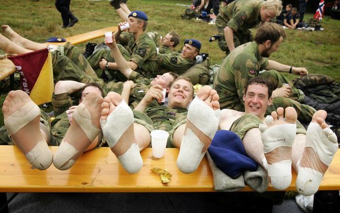 WIJCHEN - Noorse militairen die vorig jaar deelnamen aan de 92ste editie van de Nijmeegse Vierdaagse geven hun voeten rust langs de route. De Internationale Vierdaagse Afstandsmarsen Nijmegen is werelds grootste wandelevenement. Foto ANP