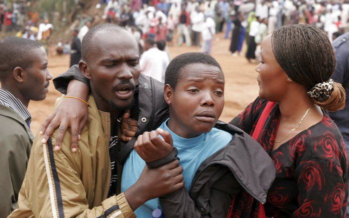 KIGALI - Rwanda herdacht dinsdag de genocide die vijftien jaar geleden begon. Een vrouw wordt, overmand door emoties, weggeleid bij de herdenkingsplechtigheid voor de genocide, waarbij meer dan 800.000 Tutsi's werden omgebracht. Foto EPA