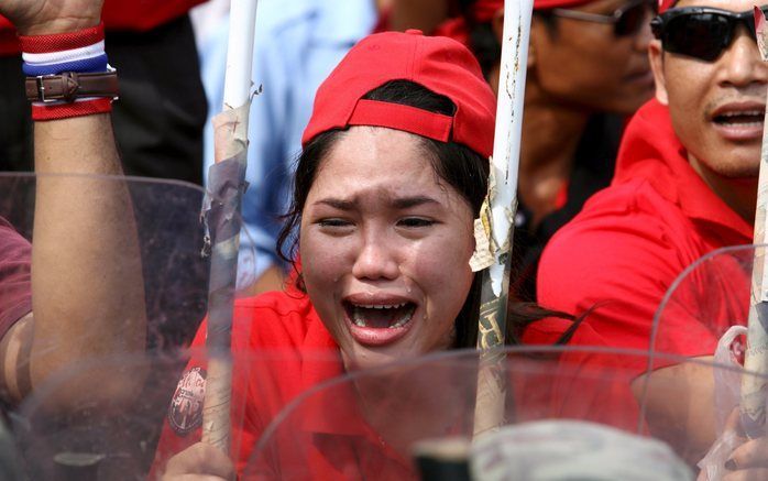 PATTAYA - Een demonstrante barst in tranen uit als ze oog in oog staat met de politie in Pattaya. Foto EPA