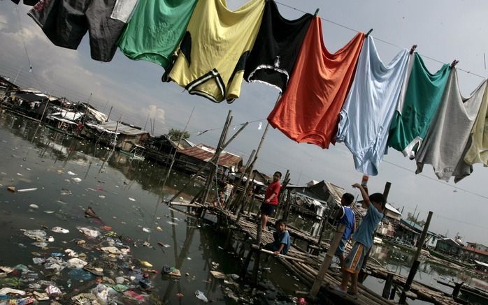 MANILA - Filipijnse kinderen spelen bij een zwaar vervuilde rivier waar muskieten veelvuldig hun eieren leggen. Foto EPA