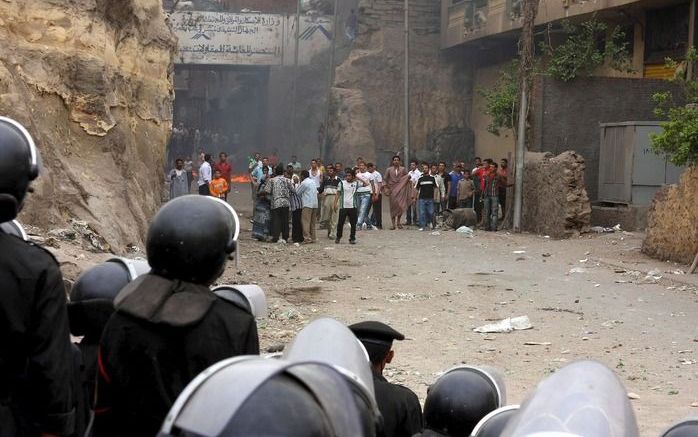 CAIRO - Varkensboeren in de Egyptische hoofdstad Caïro hebben zich zondag verzet tegen het ruimen van hun dieren. Tussen de driehonderd en vierhonderd mensen gooiden flessen en stenen naar de politie, die de varkens kwam verwijderen. Foto EPA