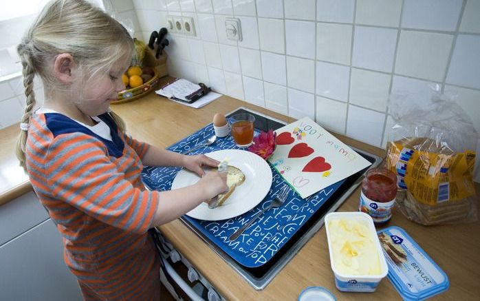 Een meisje maakt een ontbijtje voor moeder klaar. Foto ANP