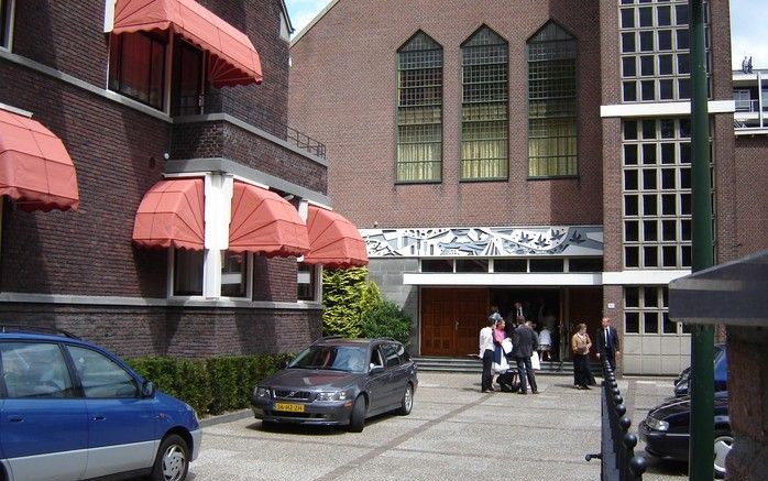 Cursisten praten nog wat na voor de kerk aan de Rotterdamse Boezemsingel, waar zaterdag de sluitingsbijeenkomst van de Cursus Godsdienst Onderwijs (CGO) van de Gereformeerde Gemeenten werd gehouden. Links op de foto het gebouw van de Theologische School. 