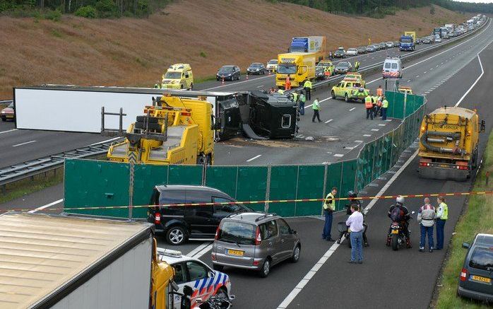 HOENDERLOO - Een gekantelde vrachtwagen ligt maandag dwars over de A1 bij Hoenderloo. De politie sloot de weg in beide richtingen af, waardoor er lange files ontstonden. Foto ANP