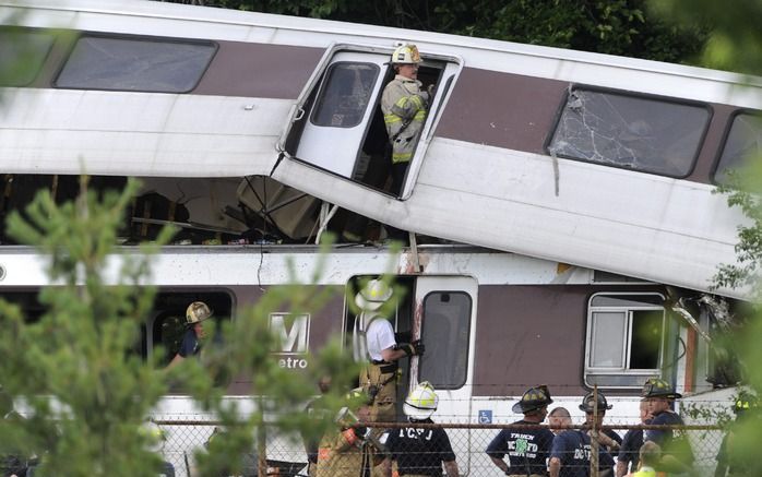 WASHINGTON - Hulpverleners proberen slachtoffers uit de op elkaar gebotste metrotoestellen te halen. Foto EPA