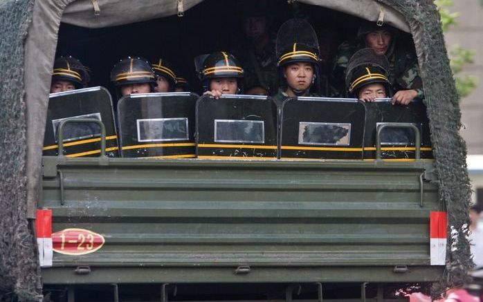 Chinese militairen achterin een legertruck op weg naar Urumqi. - Foto EPA