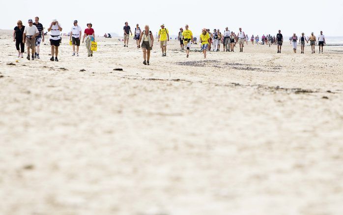 Deelnemers aan de 51e editie van de Strandzesdaagse lopen zaterdag de laatste kilometers op weg naar de finish in Huisduinen, Den Helder. Foto ANP