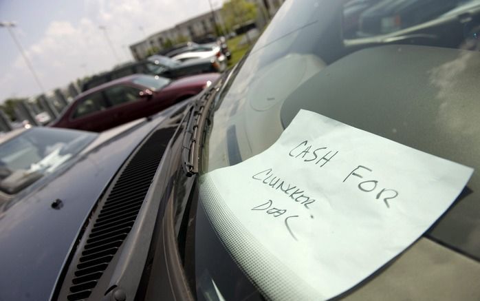 Een oude Amerikaanse auto met een briefje 'cash for clunkers' achter de ruit. Cash for clunkers betekent dat mensen een premie kunnen krijgen voor het inruilen van oude, vervuilende auto's. Foto EPA