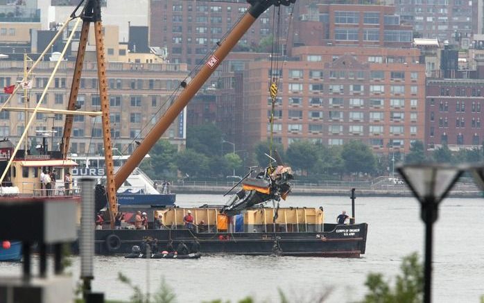 Wrakstukken van het vliegtuigje en de helikopter worden uit de Hudson getakeld. Foto's EPA