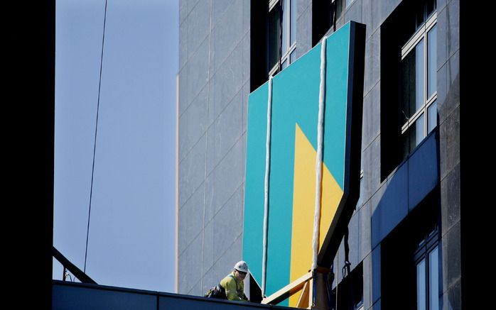 ABN Amro heeft zijn hoofdkantoor aan de Zuidas in Amsterdam dinsdag weer proberen te voorzien van het eigen logo. Dit beeldmerk werd in de zomer van vorig jaar verwijderd nadat de bank was overgenomen door een consortium van Fortis, Royal Bank of Scotland