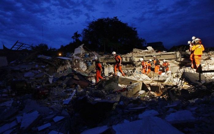 JAKARTA - Ook als de avond valt zoeken reddingswerkers door. Foto EPA