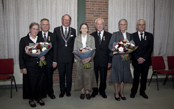 BEEKBERGEN – Burgemeester De Graaf (met ambtsketen) poseert met de drie gedecoreerde SGP’ers en hun echtgenotes. V.l.n.r. J. A. Jochems, A. Wilbrink en W. F. Stufken. Foto André Dorst