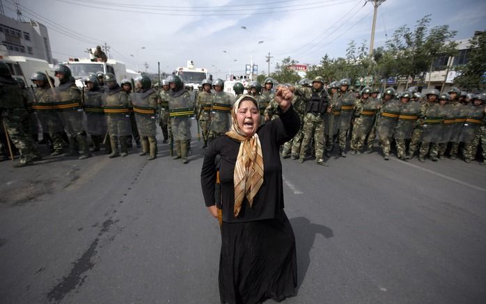 Een vrouwelijke Oeigoer betoogt in Urumqi. Foto EPA