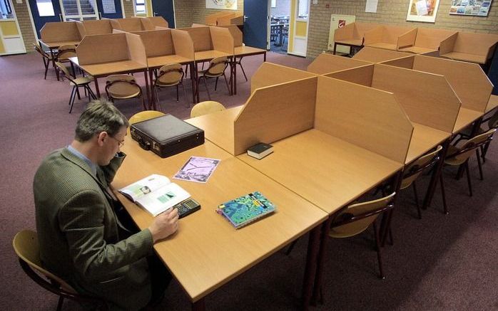 De Jacobus Fruytier Scholengemeenschap staat zaterdag met een reünie stil bij haar 25-jarig jubileum. Op de foto: Een handvol docenten van de reformatorische scholengemeenschap Jacobus Fruytier in Apeldoorn werkt wat voor zichzelf in de lege lokalen. Foto