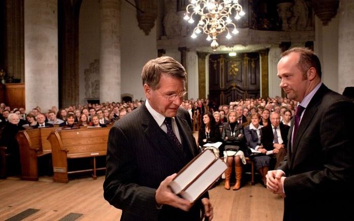 DORDRECHT – In de Grote Kerk in Dordrecht had zaterdagavond een nationale Reformatieherdenking plaats. Minister J. P. H. Donner nam van uitgever Kees den Hertog (rechts) het eerste exemplaar van de nieuwe vertaling van Calvijns Institutie in ontvangst. Fo