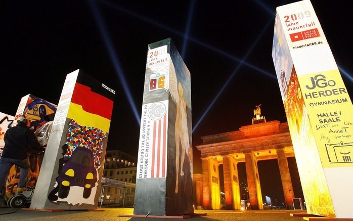 Dominostenen bij de Brandenburger Tor symboliseren de plaats waar de Berlijnse Muur stond. Foto EPA