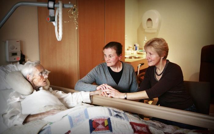 Mieke Post (m.) en Grietje Posthouwer aan het bed van een bewoner van Hospice Nijkerk. Foto RD, Henk Visscher