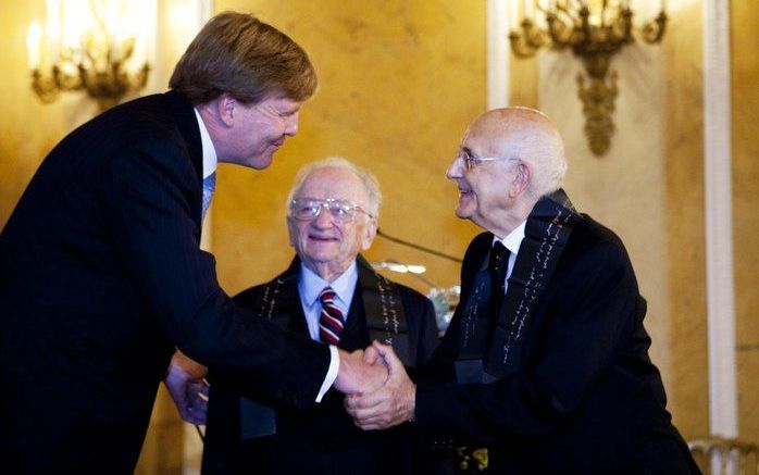 Prins Willem Alexander schudt vrijdag de hand van de Italiaanse jurist Antonio Cassese (R) terwijl de Amerikaanse jurist Benjamin Ferencz (M) toekijkt. Foto ANP