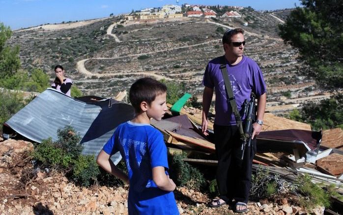 Joodse kolonisten bij een vernield gebouw van een illegale nederzetting. Een bouwstop in Joodse nederzettingen vormt voor de Palestijnen een voorwaarde om de vredesbesprekingen te hervatten. Foto EPA