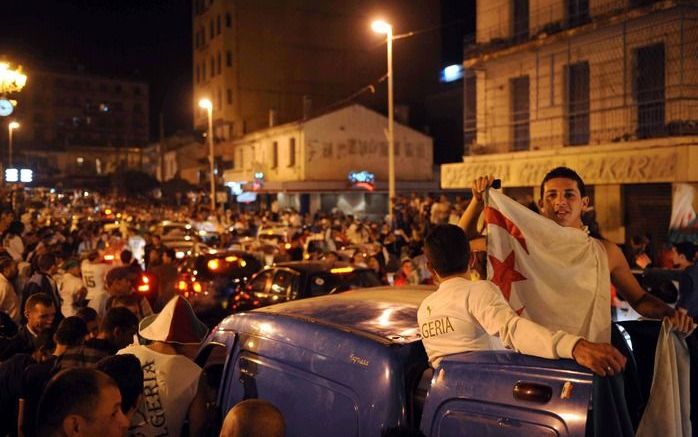 Uitzinnige Algerijnen vieren de overwinning in de straten van Algiers. Foto EPA