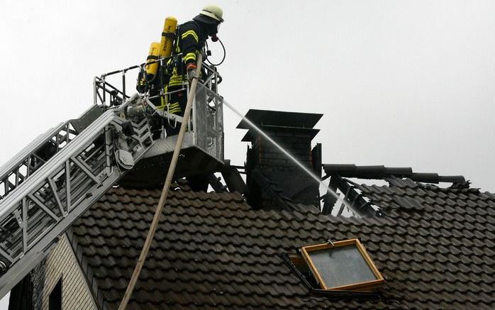 De Duitse brandweer bij het huis waar meerdere mensen de dood vonden. Foto EPA