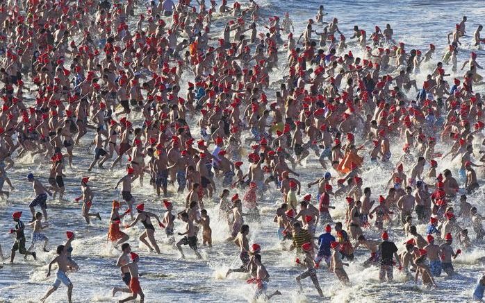 Voor de traditionele nieuwjaarsduik in de Noordzee kwamen vrijdagmiddag 8600 mensen in Scheveningen opdraven. Foto ANP