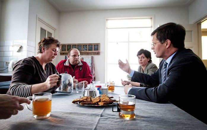 HULTEN - Premier Balkenende (R) zit woensdag aan tafel bij Andre (2e van links) en Karin Wouters (L) op hun geitenhouderij in Hulten. Foto ANP