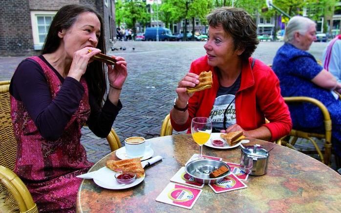 Laura (l.) en Beppie kletsen bij op een terrasje. Foto De Regenboog Groep