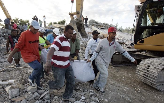 PUERTO PRINCIPE – Een groep vrijwilligers draagt een lichaam weg in Puerto Principe, even ten westen van de Haïtiaanse hoofdstad Port-au-Prince. Mogelijk hebben vele tienduizenden slachtoffers de aardbeving van dinsdag niet overleefd. Foto EPA