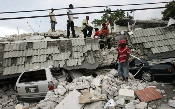 Mannen verwijderen puin van een gebouw in Port-au-Prince. Foto EPA