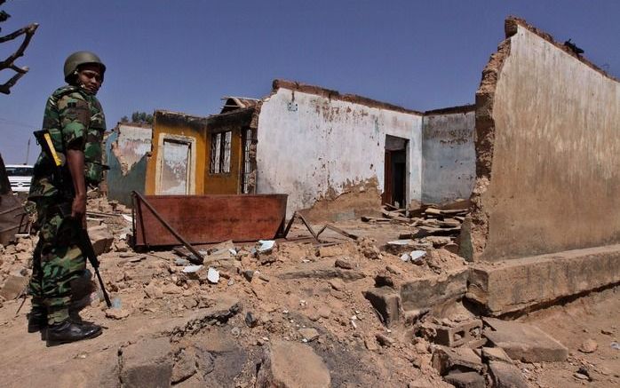 Een Nigeriaanse soldaat patrouileert bij een verwoest huis in Jos, Nigeria, 20 januari 2010. Foto EPA