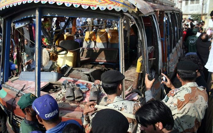 Soldaten onderzoeken de opgeblazen bus. Foto EPA