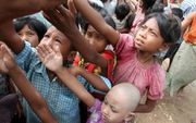 Birmese kinderen in de rij voor drinkwater in Thongwa. Foto EPA