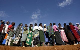 Keniaanse vrouwen staan in de rij voor voedsel in Nairobi. Het World Food Program deelt in sloppenwijken van Nairobi voedsel uit. Foto EPA