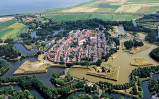 NAARDEN-VESTING - Een van de best bewaarde vestingsteden van Europa is Naarden. De stad, die ooit aan zee lag, kreeg in 1300 zijn stadsrechten. De vesting heeft een dubbele bewalling en een dubbele grachtengordel, zes bastions, met aarde bedekte wallen, k