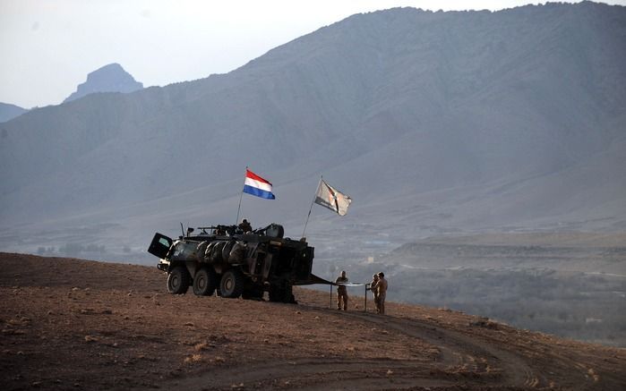 Nederlanse militairen zetten hun tent op voor de overnachting in de Choravallei, Uruzgan, 21 januari. Met de kabinetscrisis trekt Nederland zich naar alle waarschijnlijkheid als eerste NAVO-partner terug uit een moeizame oorlog. De NAVO heeft de Afghanen 