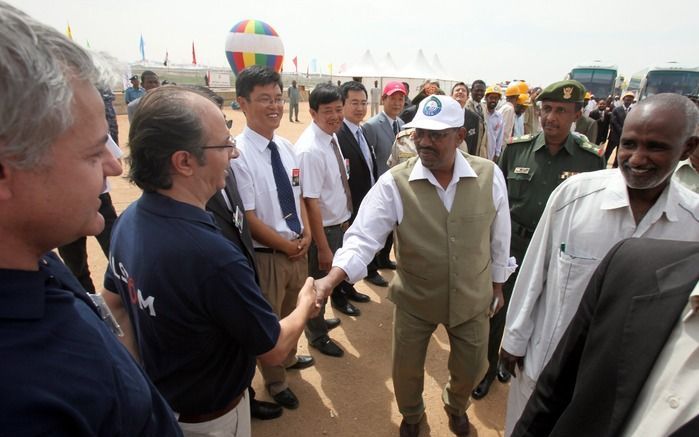 Zittend president Al-Bashir schudt enkele handen. Foto EPA.