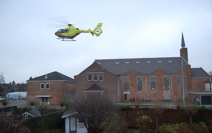 OPHEUSDEN - De traumahelikopter hangt boven de gereformeerde gemeente in Nederland. Foto RD