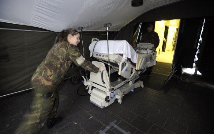 ENSCHEDE – Korporaals Lesley Arrighi en Andre Huisman richten het noodhospitaal in dat in de nacht van donderdag op vrijdag is neergezet op een parkeerplaats bij het Medisch Spectrum Twente. Vanochtend is de mobiele afdeling geopend, de eerste twee patiën