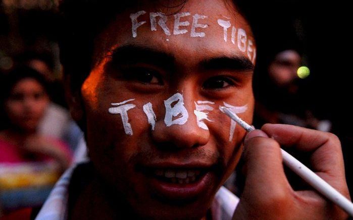 Een Indiase betoger schildert 'Free Tibet' op zijn gezicht. Foto EPA